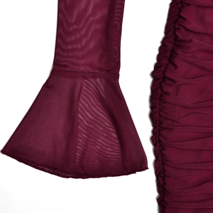 Détail du tissu en maille rouge foncé avec texture plissée et manche cloche évasée