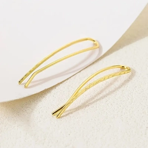 Minimalist gold metal earrings with U-shaped smooth and textured surface design