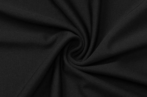 Dettaglio del tessuto in pizzo nero che mostra la trama a maglia e il drappeggio morbido
