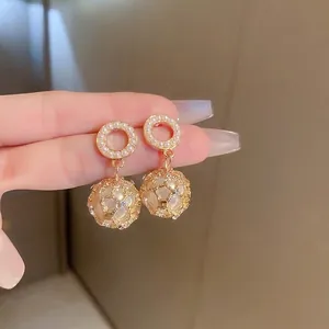 French vintage gold hollow mesh ball earrings with pearls shown in hand close-up