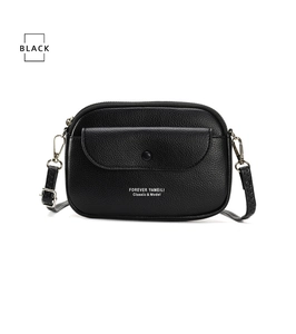 Detail of black crossbody bag featuring pebbled leather texture and adjustable strap