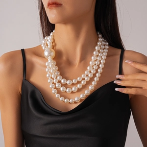 Close-up of three-layer asymmetric faux pearl necklace with large focal bead on model