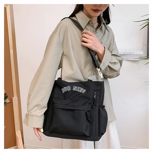 Detail of black nylon tote bag with DUO NING print and adjustable shoulder strap