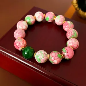 Handcrafted floral ceramic beaded bracelet with gold plating and green accent bead