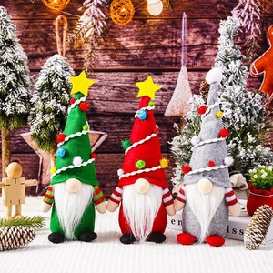Three festive Christmas gnomes with colorful striped cone hats and white beards in a cozy setting