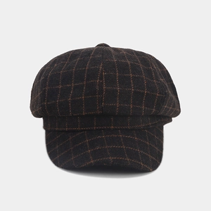 Close-up of brown plaid newsboy cap showing wool texture and octagonal stitching details