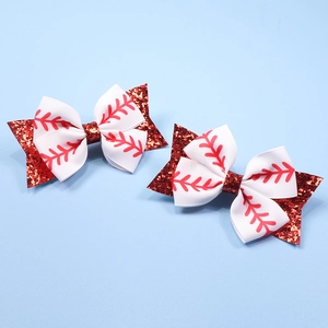 Detail of red glitter hair clips with baseball pattern bows and white ribbon trim