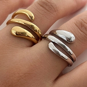 Detail of minimalist layered wrap rings in polished gold and silver finishes