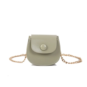 Mini sac selle vert haricot chic avec chaîne dorée et coutures fines sur fond blanc immaculé