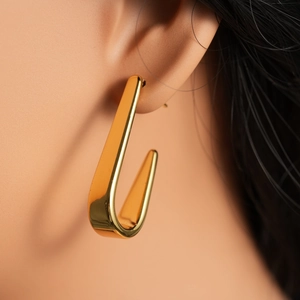 Minimalist U-shaped geometric earrings in 18k gold plating worn by model