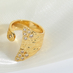 Detailed close-up of a vintage hammered gold open ring with sparkling cubic zirconia stones