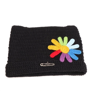 Detail of cute cat ear knit hat with colorful crochet flower and silver safety pin