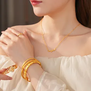 Vintage gold necklace and layered brushed bracelets set worn by a female model