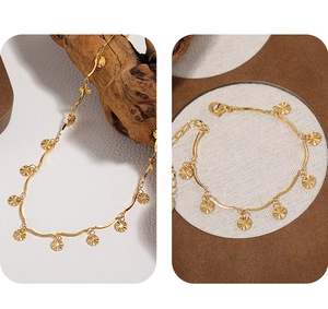 Detail of golden wavy link chain necklace with radiant sunburst textured pendants
