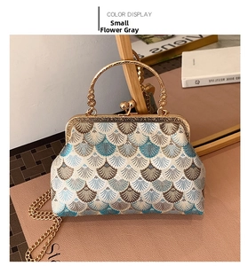 Detailed view of grey embroidered flower pattern on vintage handbag with gold chain handle