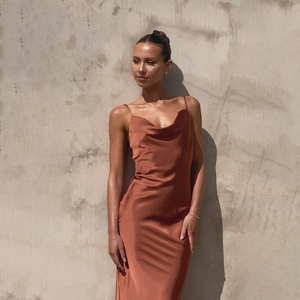 Detailed view of bronze satin slip dress with deep V-neck and slim fit silhouette