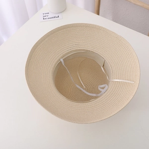 Détail de l'intérieur du chapeau de paille montrant la mentonnière élastique blanche