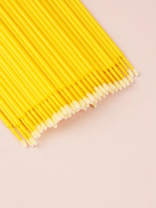Macro shot of yellow disposable microbrushes with white tips for eyelash extensions