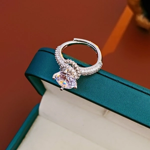 Macro shot of polished silver zircon ring on luxury green velvet box edge detail