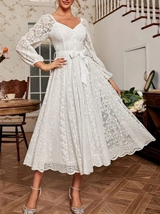 Détail de la dentelle florale blanche et de la ceinture en satin sur cette robe élégante