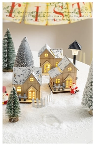 Three glowing wooden Christmas houses with warm LED lights and snowy texture decorations
