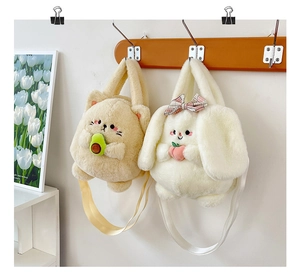 Detail of plush cat and rabbit crossbody bags with fruit accents and adjustable straps