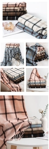 Detail showing various plaid scarves with tassels in multiple colors on a chair