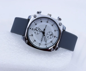Detail of square quartz watch featuring rhinestone markers and gray silicone strap