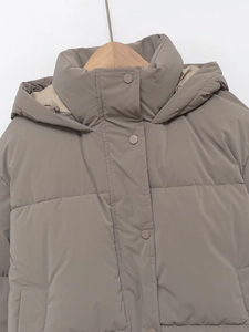 Close-up of the taupe padded jacket featuring a stand-up collar, hood, and snap buttons