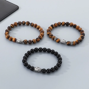 Macro detail of men's beaded bracelets with tiger eye stones and silver Buddha heads