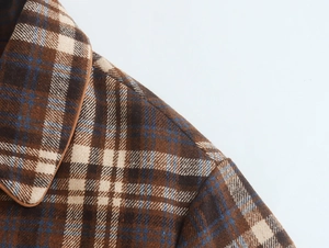 Detailed macro view of the lapel and shoulder of a brown plaid woolen jacket for women