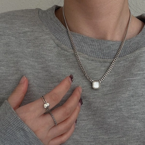 Detail of silver bow necklace set with square diamonds on a model for lifestyle view