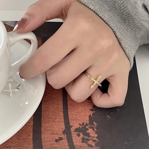 Detailed view of two minimalist cross rings with subtle diamonds on a gold and silver finish