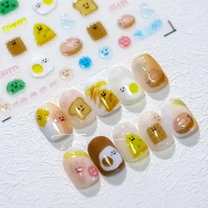 Detail of 3D embossed nail art stickers featuring cartoon eggs and toast patterns