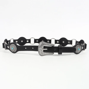 Detail of vintage punk belt with turquoise inlay and carved silver buckle on black leather
