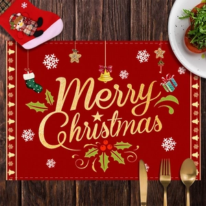 Close-up of red Christmas placemat with golden Merry Christmas text and holiday motifs