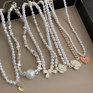Baroque pearl necklaces with camellia and heart pendants on a display tray