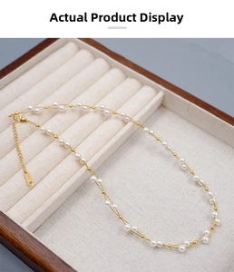 Macro detail of pearl necklace featuring gold beads, lobster clasp and extension chain