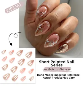 Short almond press on nails with nude pink finish, rose gold glitter and white flower detail