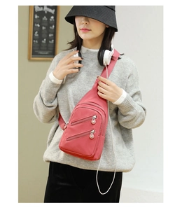 Pink nylon crossbody chest bag for women styled across the shoulder in a casual setting