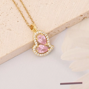 Detail of gold heart pendant with pink pear-cut crystals and sparkling zircon accents