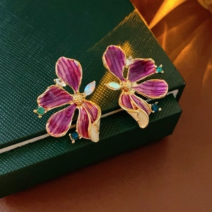 Makro-Detail von Vintage-Ohrringen mit lila Blüten und bunten Kristall-Akzenten