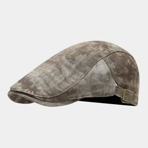 Detailed side view of vintage tie-dye ivy cap with brass buckle and washed cotton texture