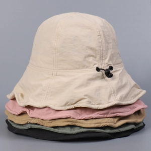 Detail of colorful water-repellent sun hats with adjustable toggles in a stack
