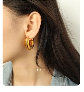 Close-up of 18K gold-plated irregular ridged hoop earrings on model with retro texture