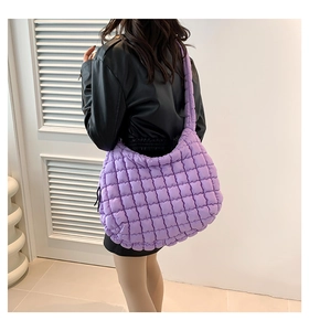Close-up of a vibrant purple quilted shoulder bag showing plush texture and strap detail