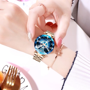 Detail of rose gold ladies watch with faceted starry blue dial and woven mesh band