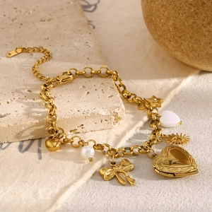 Detailed close-up of 18K gold plated chain bracelet with heart, bow, and pearl charms