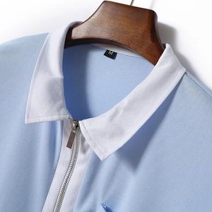 Close-up of light blue polo shirt collar with white trim, zipper, and pique texture