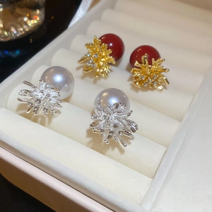 Close-up of pearl fireworks earrings with sparkling diamonds on velvet jewelry tray